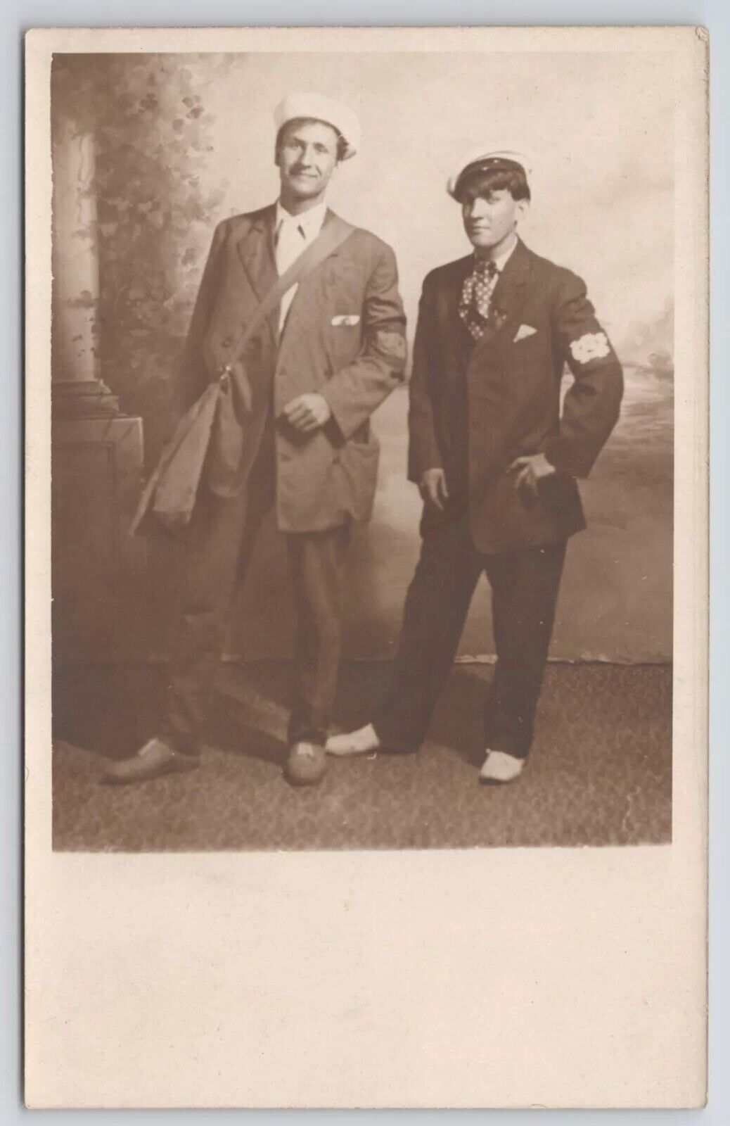 RPPC Men Standing In Studio Messenger Bag Arms On Hip c1910 Real Photo Postcard