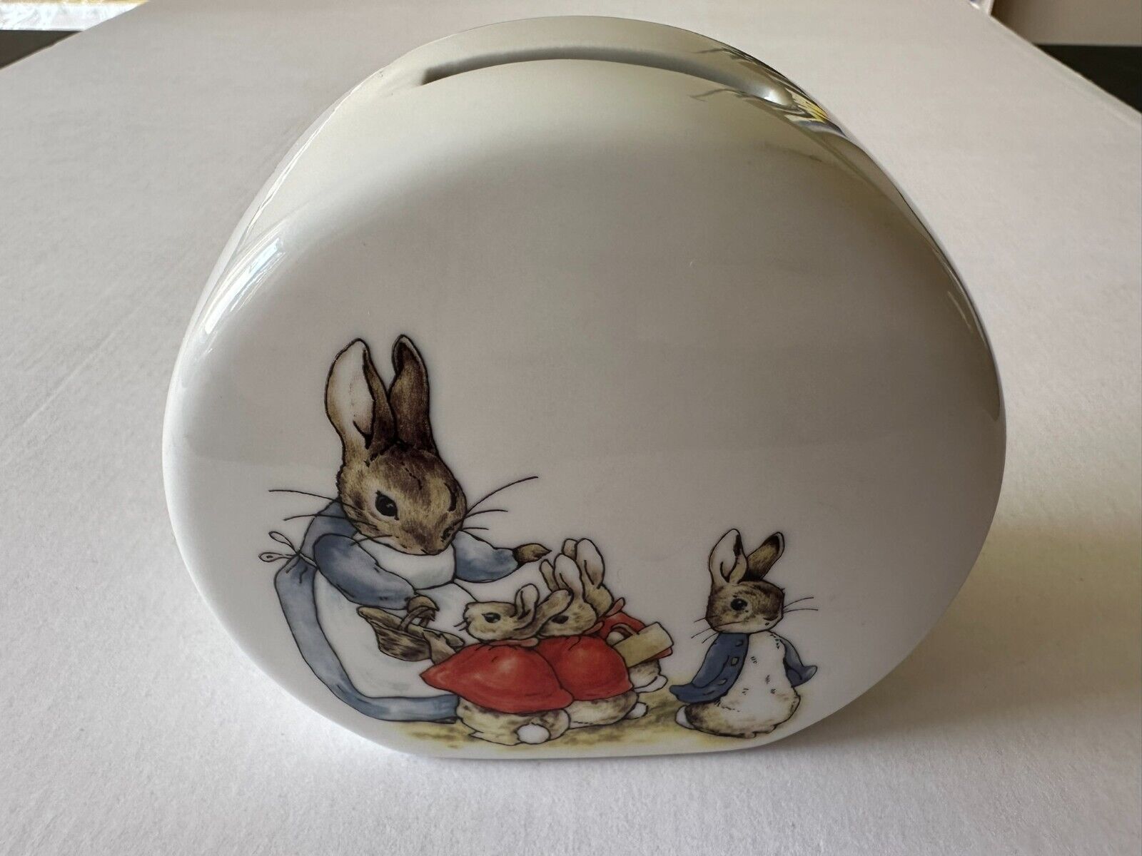 White ceramic coin bank with bunny rabbit family illustration print German