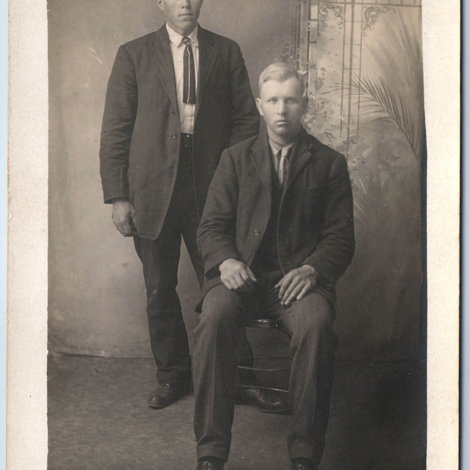 c1910s Handsome Two Men Portrait RPPC Short Tie Fake Studio Window Photo PC A213