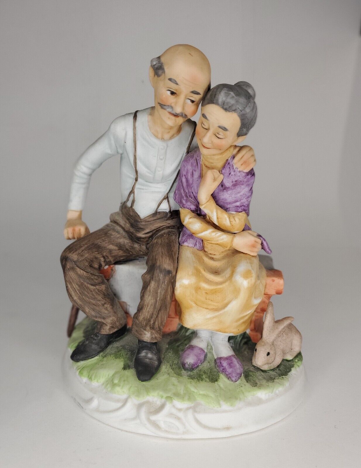 Loving Older Couple Hugging Figure. Man with Cane & Woman with Rabbit