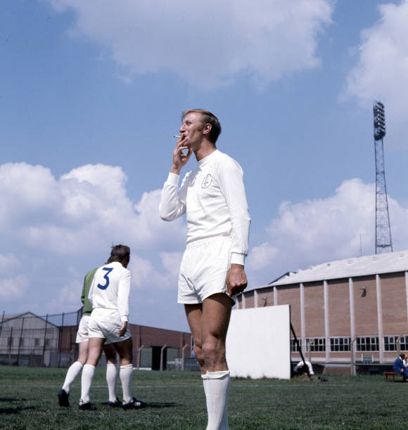 Leeds United footballer Jack Charlton smoking during a training se - Old Photo