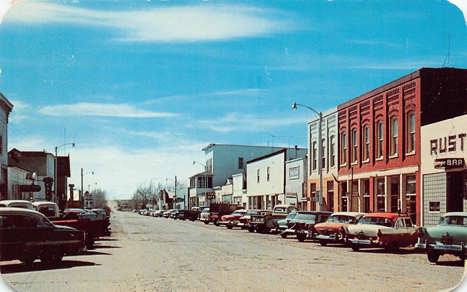 Saratoga WY Wyoming Main Bridge Street Rustic Bar Sun Newspaper Vtg Postcard C14
