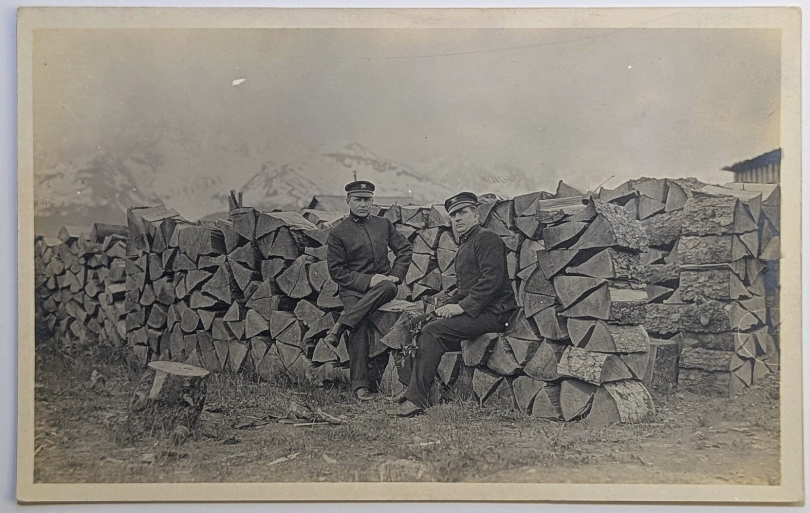 ​Antique RPPC Men in Uniform Peaked Caps Firewood Stack Mountain Views 1907-1914