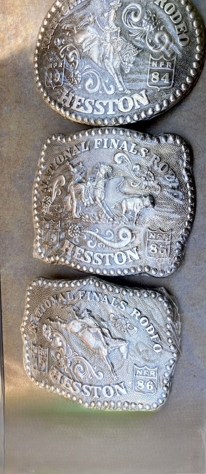 New Hesston Belt Buckles, 1984 to 1986, \'84 w/papers, in original shrink wrap